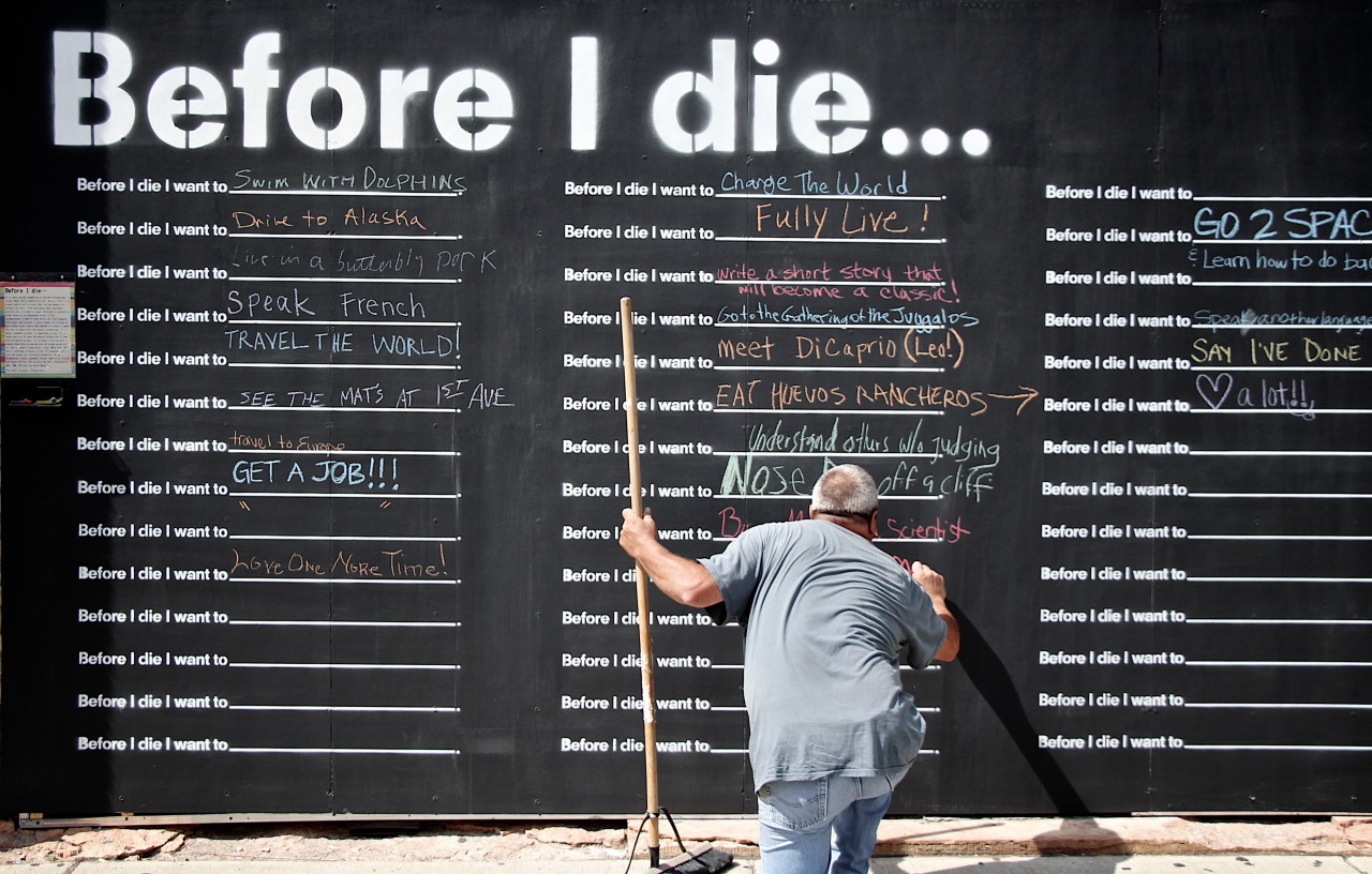 Before I Die is a global public art project that invites people to reflect on their lives and share their personal aspirations in public space. It was originally created by artist Candy Chang on an abandoned house in her neighborhood in New Orleans after she lost someone she loved. This wall is located in the North Loop neighborhood of Minneapolis at 212 3rd Avenue North. The guy writing in the photo wrote that he wanted to ‘punch Obama’. Hey